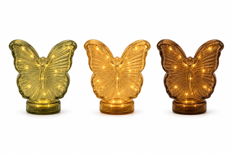Three illuminated butterfly-shaped glass lights in green and amber tones