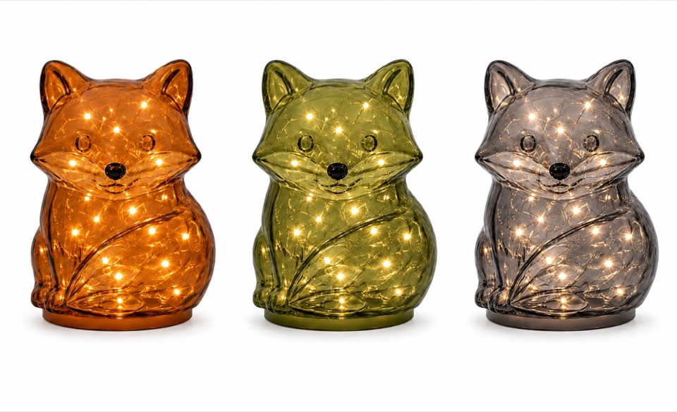 Three illuminated fox-shaped glass lights in amber, moss, and smoke