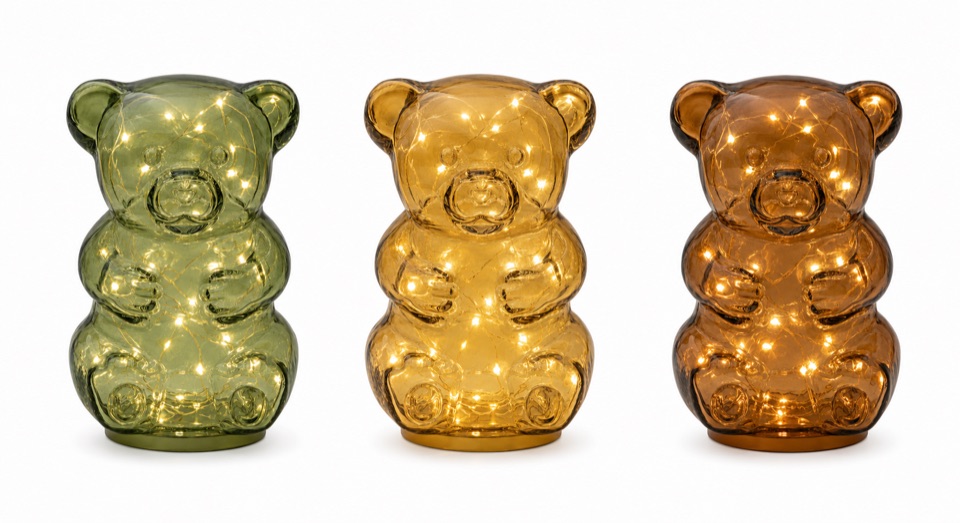 Three illuminated bear-shaped glass lights in sage, honey, and amber