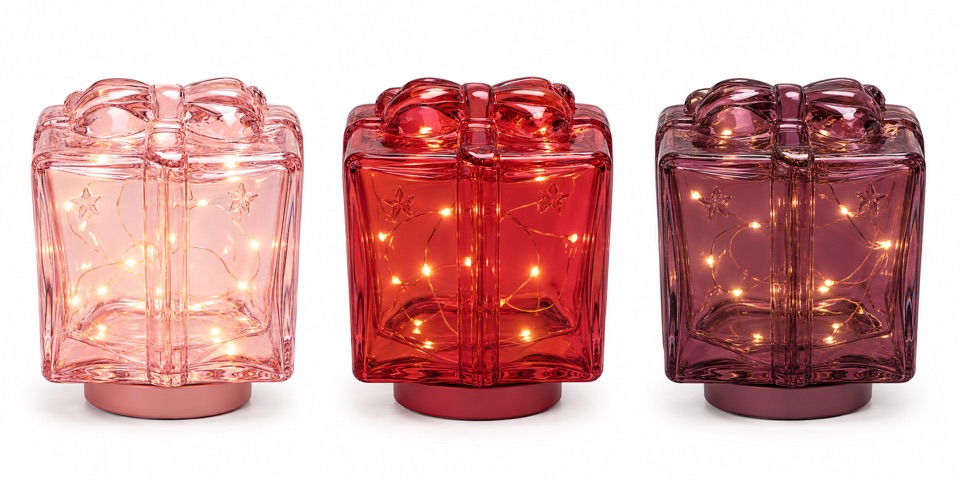 Three illuminated glass gift-box lights in blush, ruby, and mulberry